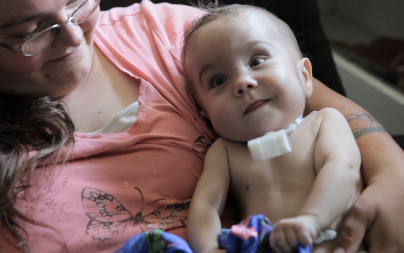 Photo of mother and her child with 3D printed splint attached to his neck
