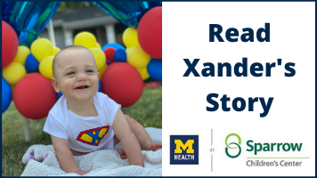 Xander outdoors smiling with balloons in background