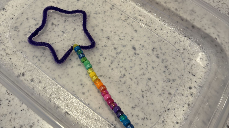 Pipe cleaner shaped as a star with string of beans for wand