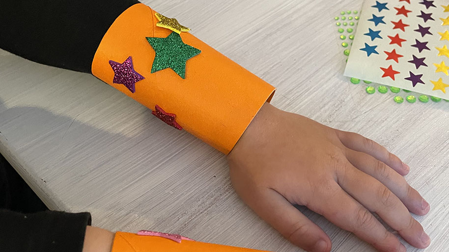 Child with superpower orange cuffs on decorated with stars