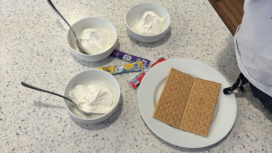 Bowls of whipped cream, painting canvas and powder packets for project.