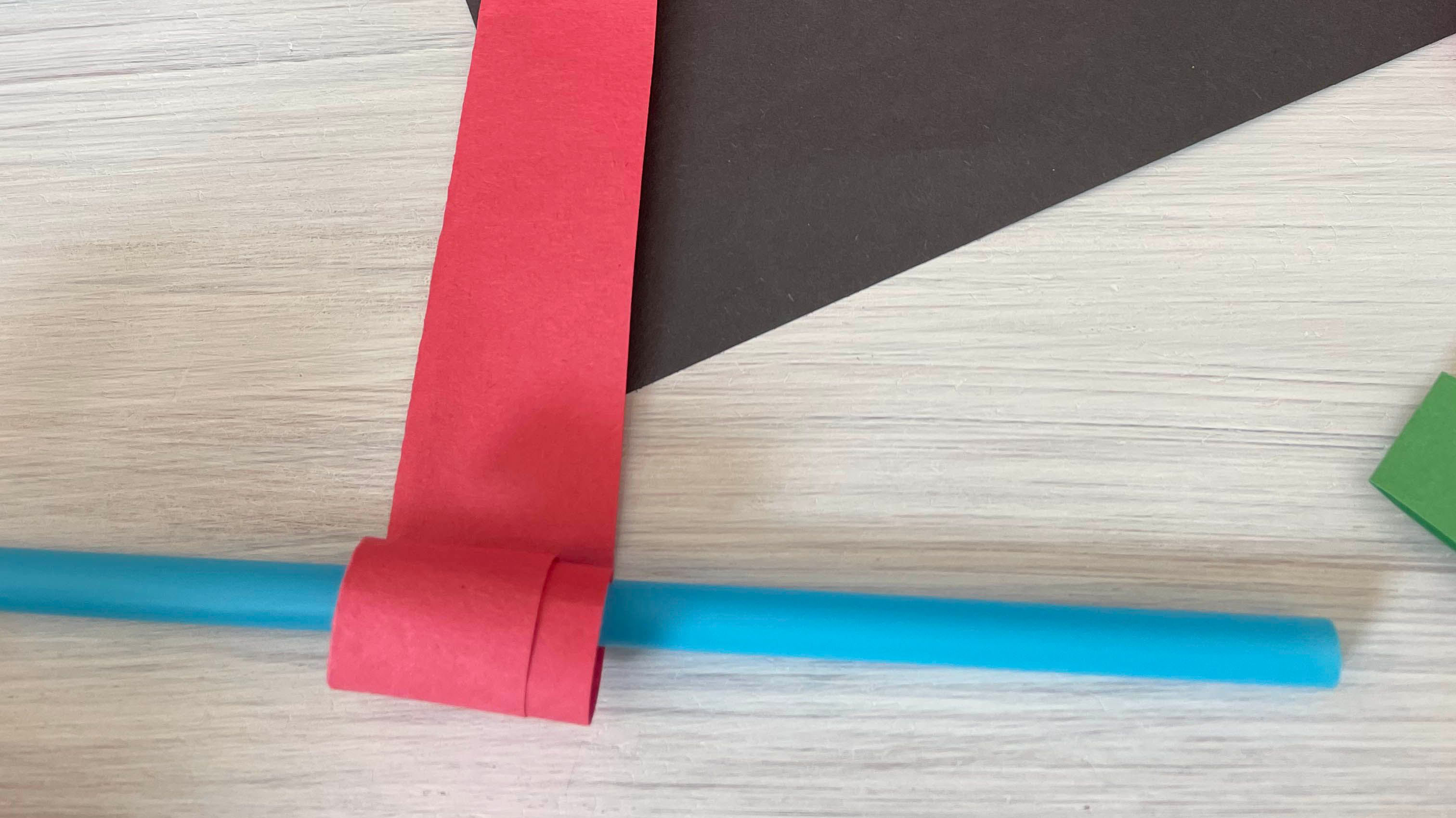 Colorful paper cutouts and green straw for frog science and math project