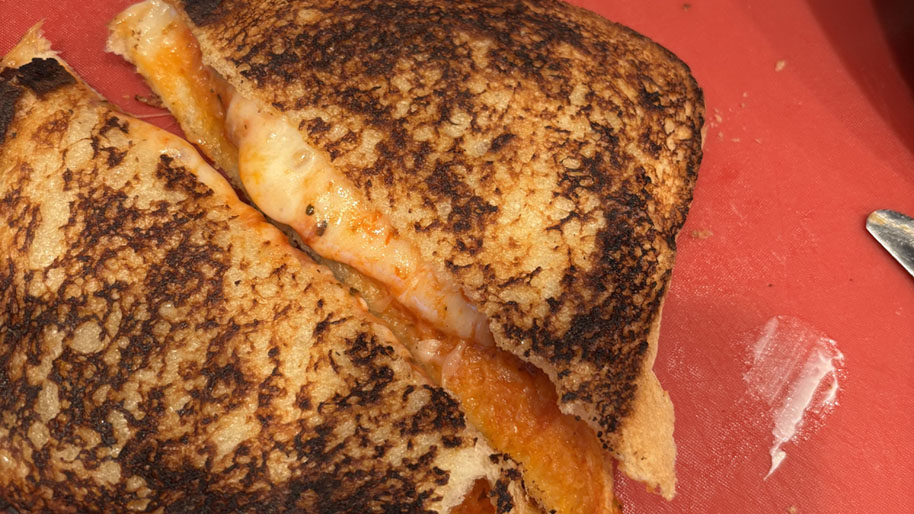 Homemade cheesy pizza sandwich on a red place.
