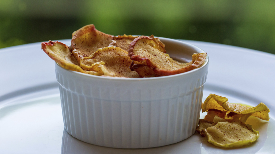 White bowl filled with cinnamon apple chips