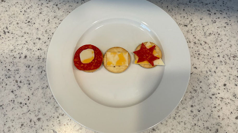 Pepperoni, cheese star shapes shields decorated on a plate