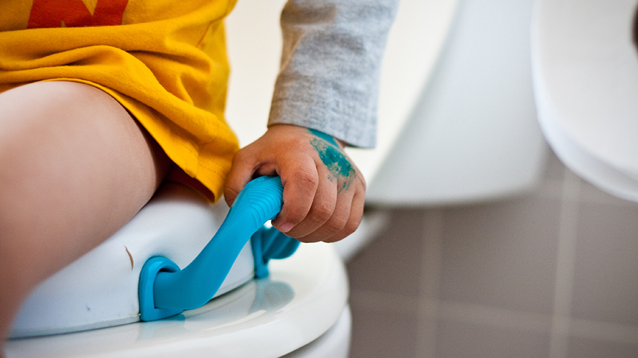 child sitting on a toilet