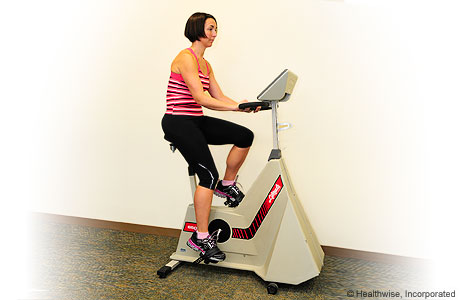 A woman exercising on a stationary bike A woman exercising on a stationary bike
