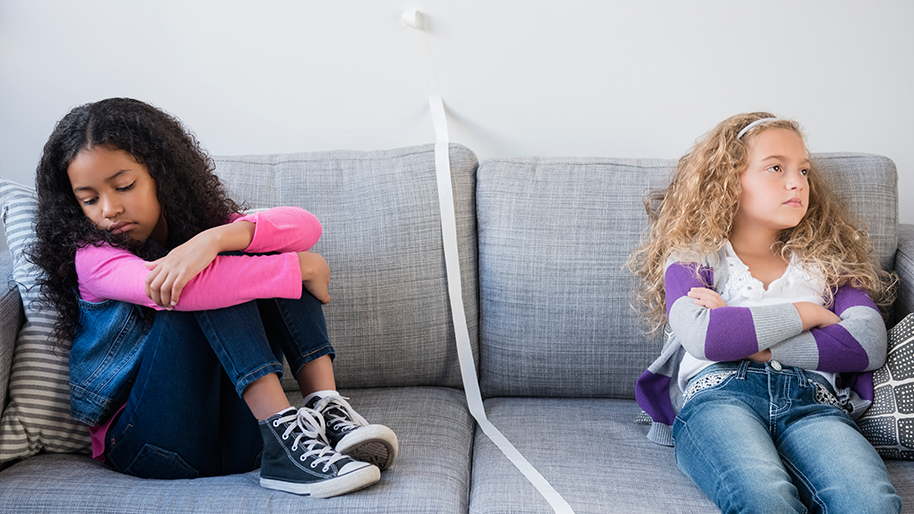Two girls on a sofa arguing