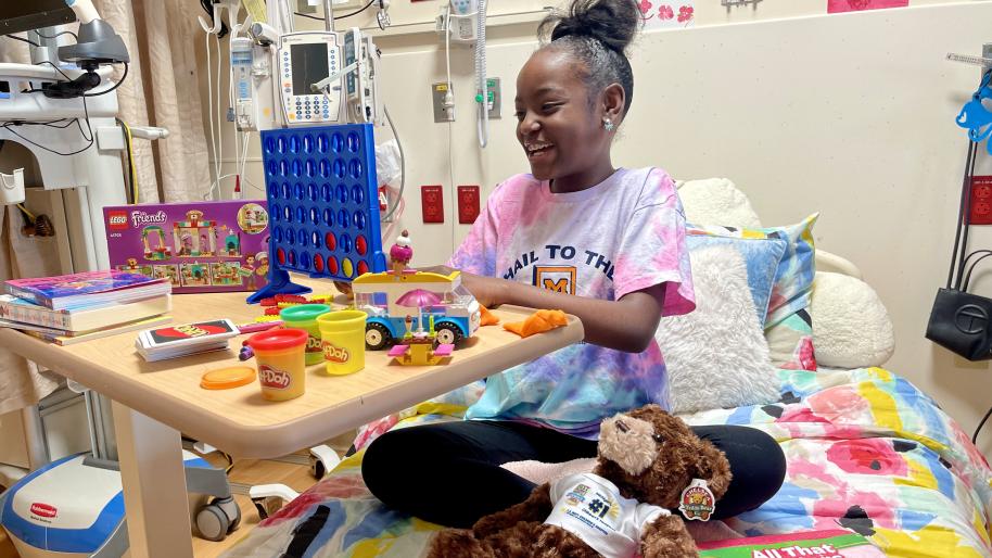 young female patient smiles with toys on her bed