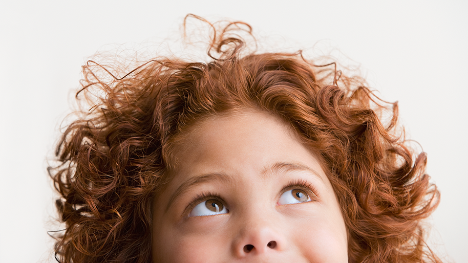 Child with curly red hair looking up