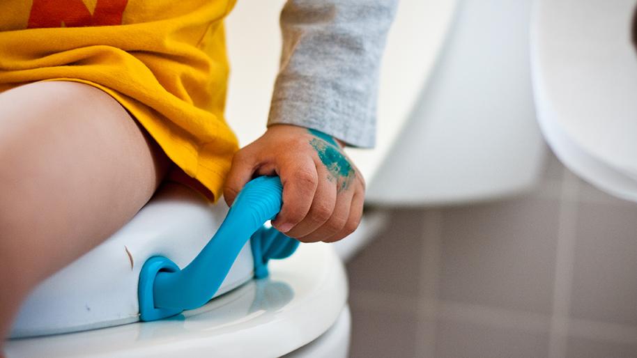 child sitting on a toilet