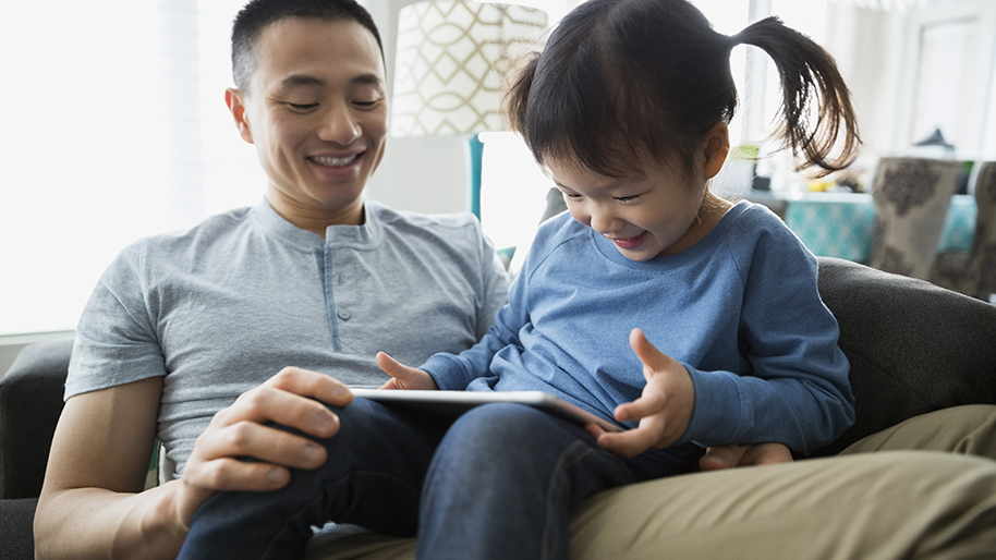 Father and daughter looking at a tablet