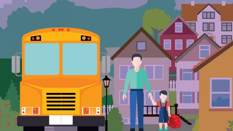 Photo of parent and child standing next to school bus