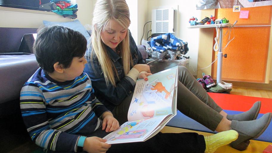 Teacher in a hospital room reading to a child