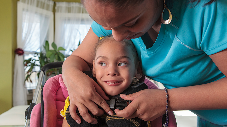Child receiving assistance from a caregiver