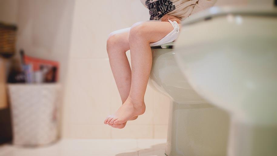 Child's legs dangling while sitting on the potty