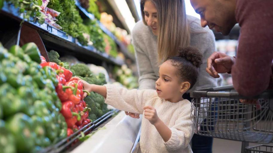 children with parent in produce section of grocery store