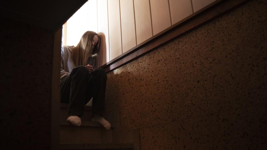 Young girl sitting at the top of stairs
