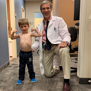 Max Weigel flexing in clinic alongside his pediatric cardiologist.