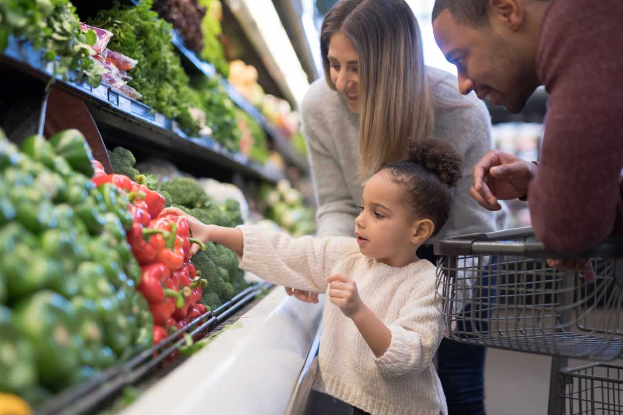 children with parent in produce section of grocery store