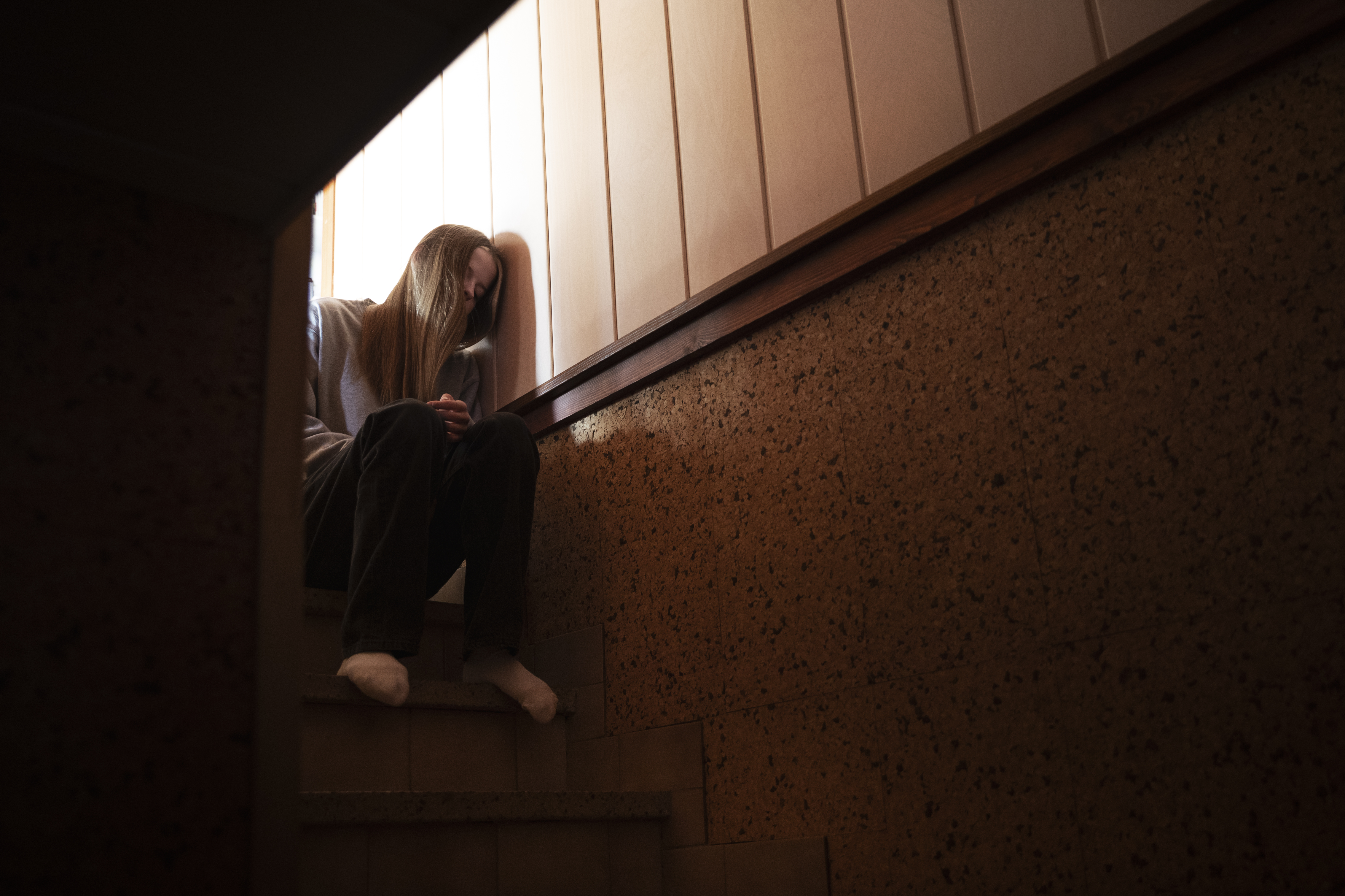 Young girl sitting at the top of stairs